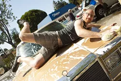 PIN-UP KING! : Mike strikes a pose on the hood of a Chrysler. - PHOTO BY STEVE E. MILLER
