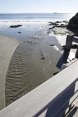 WHERE DOES IT GO? : Creeks that empty into the ocean, like this one flowing into Avila Bay, carry along debris and fluids washed from storm drains and gutters. County supervisors recently tentatively approved a new ordinance written to protect local waters from chemicals and trash. - PHOTO BY STEVE E. MILLER