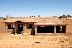 INTERESTED IN HALF A HOUSE? : Work has stopped on this half-finished Paso Robles house. It's one of dozens financed through 21st Century and other hard-money lenders that are now in the foreclosure process. - PHOTO BY STEVE E. MILLER