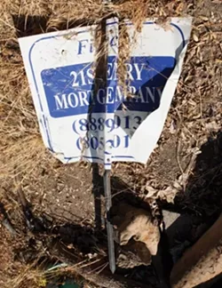SIGN OF TROUBLE: : This crumpled and discarded 21st Century Mortgage sign was in a trash pile at the site of BR302, a now-abandoned project in the middle of a Sycamore-lined Atascadero neighborhood. - PHOTO BY STEVE E. MILLER