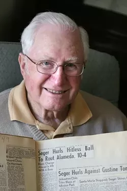 WHAT’S UP DOC? : San Luis Obispo’s own Moonlight Graham, Dr. Charles Seger, holds up a scrapbook of his accolades, compiled by his wife, who passed away just a few months ago. Seger played with the Blues from 1949-1958 and even managed the squad for one season. After hanging up his glove, “Doc� Seger coached youth baseball in San Luis Obispo. - PHOTO BY CHRISTOPHER GARDNER