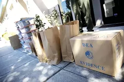 TAKE IT AWAY : Unpacking shot - Detectives seized more than marijuana from Central Coast Compassionate Caregivers. They also carted away several hard drives, bags of items, and cardboard boxes. - PHOTO BY JESSE ACOSTA