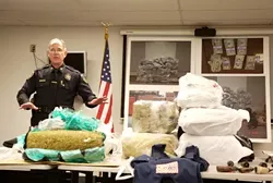 A LOT OF DOPE : On Jan. 24, SLOPD Capt. Dan Blanke stood behind a table displaying a fraction of the almost 750 pounds of marijuana seized during a yearlong investigation into an international smuggling ring that ran through San Luis Obispo. - PHOTO BY JESSE ACOSTA