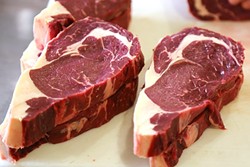 EAT WELL:  Local grass-fed beef from PC Cattle Co. shows off a dark wine color and gorgeous marbling. - PHOTO BY DYLAN HONEA-BAUMANN