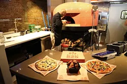 825 DEGREES: Head chef Jeremy Limpangug oversees the firing of a custom ‘za. - PHOTO BY DYLAN HONEA-BAUMANN