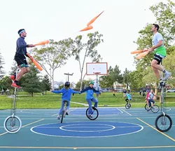 AN ARMY OF ONE (WHEELERS): The duo Something Ridiculous, which is made up of VonJon and Mark Wilder, juggles on unicycles at Meadow Park while young unicyclists practice. Every Tuesday at 4:30 p.m., Wilder and a few of his teammates from the SLO Ballerz unicycling basketball team set aside some time to teach kids and anyone else who is interested how to unicycle. - PHOTO BY DYLAN HONEA-BAUMANN