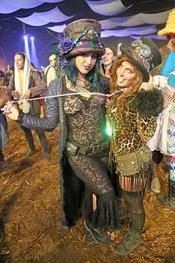CELEBRATING SEXY: Zoe Elliott (right), held by her girlfriend Treanna Dearrillaga (left), says that she feels sexy to be seen by others and hopes people get a kick out of it. “We just like to add to the experience and just be fucking weirdoes at a festival,” Dearrillaga said. - PHOTO BY DYLAN HONEA-BAUMANN