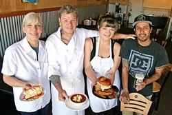 FACTORY WORKERS : From left, Flavor Factory Chef/Owners Dawnelle and Adam Pollard, their daughter and cook Camille Pollard, and fellow employee David Ramirez. They’re holding from-scratch mango cheesecake, tortilla soup, and a juicy burger, all of which have become staples of the new Morro Bay hangout. - PHOTO BY HAYLEY THOMAS