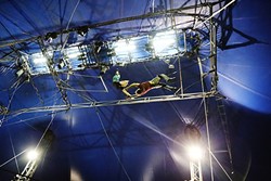 FLYING HIGH:  Circus Vargas&rsquo; Mariella Quiroga lets go of the flying trapeze before grabbing hands with Alberto Marinelli who hangs upside down from another trapeze bar during rehearsal on June 30. - PHOTO BY DYLAN HONEA-BAUMANN