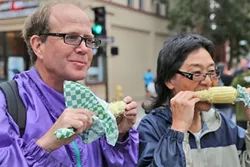 FOOD TOURISTS: Carolyn Nakano and Brett O’Sullivan, visitors from Boulder, Colo., don’t care if they’ve got corn on their face and butter dripping down their chin. - PHOTO BY DYLAN HONEA-BAUMANN