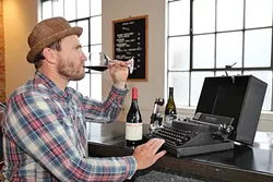 CREATIVE LUBRICANT: Darren Delmore taps on an antique typewriter at The Station in SLO, a fitting setting for his recent reading of 'Slave to the Vine: Confessions of a Vagabond Cellarhand.' - PHOTO BY DYLAN HONEA-BAUMANN