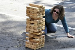 TIMBER!:  Heather Green from San Leandro looks for that perfect block to pull in a giant game of Jenga against Amy McKnight of San Dimas. The two grabbed their spouses and met in the middle for a weekend of fun in San Luis Obispo&mdash;which happened to include a stop at CCB&rsquo;s birthday celebration. - PHOTO BY CAMILLIA LANHAM