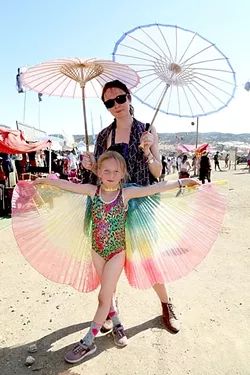 FAMILY BONDING : Marina Panda stands with her 7-year-old daughter Margarita, who’s been to three such festivals in her short life. - PHOTO BY DYLAN HONEA-BAUMANN