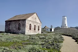 SOMETHING’S MISSING: The foghorn signal building fronts the lighthouse, now missing the Fresnel lens that once reflected light 19 miles out over the Pacific Ocean. It was removed after a 1949 earthquake caused serious damage to the lighthouse, and is now on display next to the Veterans Memorial Building on Main Street in Cambria. - PHOTO BY CAMILLIA LANHAM