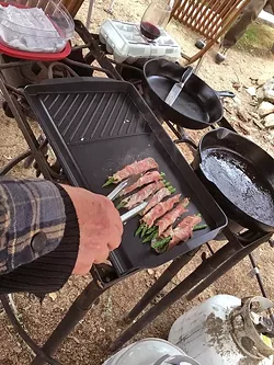 GRUB: What’s a men’s campout without decadent foods like these grilled prosciutto-wrapped asparagus with Asiago cheese appetizers? We also ate sausage, bacon, chorizo, and venison. - PHOTO BY GLEN STARKEY