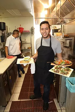 ORDER UP: Joel Casillas, co-owner of Órale Taqueria in downtown Paso Robles, shows off his serving skills with a range of Mexican delights. - PHOTO BY DYLAN HONEA-BAUMANN