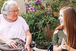 SPECIAL FRIENDSHIP: Cal Poly student Jaymi Boynton (right) exchanges a laugh with Lorraine Bailey (left), a client with Wilshire Health and Community Services. The two met through the Caring Callers Program, which connects volunteers with homebound seniors seeking companionship. - PHOTO COURTESY OF KELLY DONOHUE