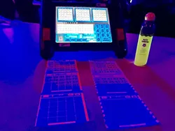 BRIGHT FUTURE : An automated bingo machine, a bingo dauber, and cards glow under black lights at the Chumash Casino. - PHOTO BY TREVER DIAS