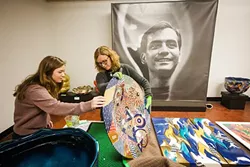 MAKING ART LOOK GOOD : SLOMA Curator Ruta Saliklis, right, and Cal Poly student Rebecca Gates, left, prepare for an upcoming exhibit featuring the works of deceased artist Ralph Bacerra. - PHOTO BY JAYSON MELLOM