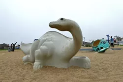 BRONTOSAURUS: A small concrete dinosaur in the Dinosaur Caves Park playground is a little reminder of the giant headless concrete dinosaur that graced the site from 1948 to 1960. - PHOTO BY GLEN STARKEY