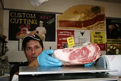 YOUR LOCAL BUTCHER: Arroyo Grande Meat Co. owner/butcher Henry Gonzalez knows his customers by what kinds of cuts they like. - PHOTO BY HAYLEY THOMAS CAIN