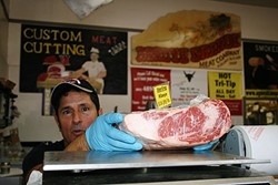 YOUR LOCAL BUTCHER:  Arroyo Grande Meat Co. owner/butcher Henry Gonzalez knows his customers by what kinds of cuts they like. - PHOTO BY HAYLEY THOMAS CAIN