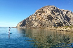 LEARNING THE ROPES:  Clare checks out Morro Rock soon after setting off on our SUPing adventure. - PHOTO BY PETER JOHNSON