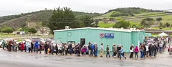 PEOPLE POWER : Hundreds of SLO County Democrats lined up in the rain Jan. 7 to help elect a slate of 14 local progressives to represent them as delegates to the state-level Democratic Party. - PHOTO BY JAYSON MELLOM