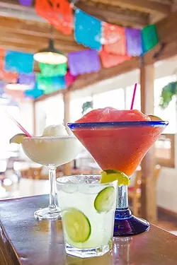 MARGARITA HEAVEN: Old Juan’s Cantina in Oceano has margaritas on margaritas—in practically any flavor you’d want. Pictured on the bar from front to back are the Cucumber Margarita, Super Strawberry Margarita, and Margarita Classico. - PHOTO BY JAYSON MELLOM