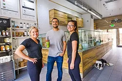 SEEDS THAT GREW: Rammy Aburashed (center) owns Seeds The Juice Company, the Best New Business of 2016 (according to our readers) and the place with the Best Açaí Bowl in the county. Ivy Thompson (left), Allaina Christy (right), and Jordan (dog) work there. - PHOTO BY JAYSON MELLOM