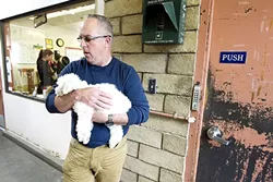 THE POUND: Eric Anderson, director of county animal services, holds a dog in the animal shelter. SLO County recently approved funding to construct a new shelter adjacent to the Woods Humane Society shelter. - PHOTO BY JAYSON MELLOM