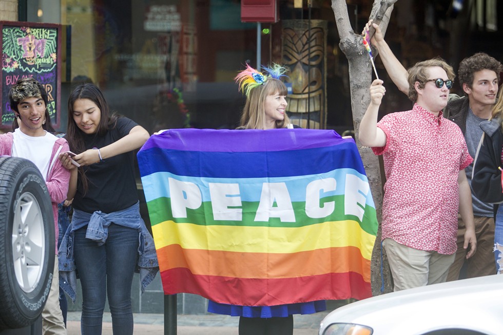 PEACE Countless rainbow Pride flags were displayed at the June 7 “Show Your True Colors” rally in downtown SLO. - PHOTO BY JASON MELLOM