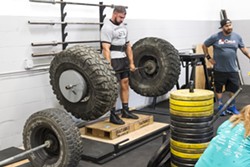 UNCOVENTIONAL Zach Wales, left, lifts a bar with oversized tires on it at Headstrong Fit. - PHOTO BY JAYSON MELLOM