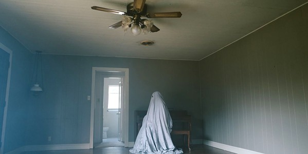 LOSS C, now a sheet-covered ghost, becomes tied to his old house through the vastness of time. - PHOTO COURTESY OF A24