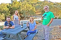 WINE RUNS IN THE FAM Lone Madrone is a family affair. From left, burgeoning winemaker Jordan Collins, Lone Madrone tasting room manager Britta Ray, General Manager Jackie Meisinger, and winemaker Neil Collins. The brother and sister duo founded the winery in 1996, and now Jordan—Neil's son—is helping out the family business. - PHOTO BY HAYLEY THOMAS CAIN