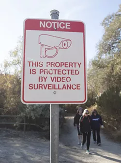 ON CAMERA A sign on the Paso Robles River Walk trail warns of surveillance cameras. - PHOTO BY JAYSON MELLOM