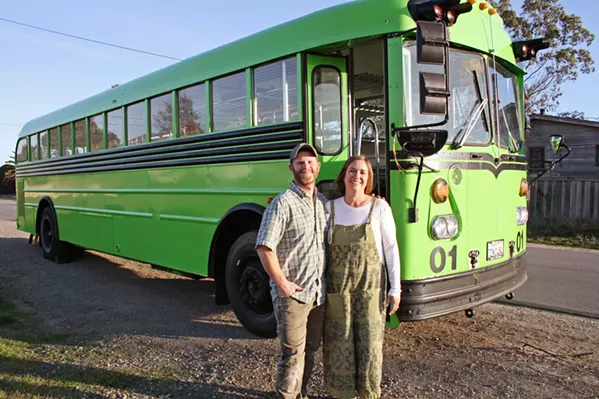 NEXT STOP, FRESH GREENS Kara Strauss, founder and owner of Bloom Microgreens in Los Osos, is the proud owner of SLO County's first functioning mobile micro-farm. Pictured with the neon green school-bus-turned-micro-farm is her husband and biggest supporter, Adam, who found the green machine on Craigslist. - PHOTO BY HAYLEY THOMAS CAIN