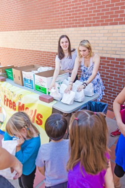 GIVING OUT FREE MEALS San Luis Obispo High School juniors (right to left) Davan Murphy and Ruby Houghton offer free meals to kids that have participated in the summer programs offered at the San Luis Obispo County Library. - PHOTO BY JAYSON MELLOM