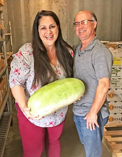 TWO VISIONARIES, ONE MELON FarmSLO founder Jeff Wade (right) stands with Director of Food Services for San Luis Coastal USD Erin Primer as she holds a Charleston Grey melon from a 100-pound box delivered by Robin Song Farms in Templeton. She said she bought them out of their harvest this time around! - PHOTO BY BETH GIUFFRE