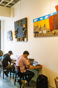 IN THE PERIPHERY Ascendo Coffee customers work under colorful, three-dimensional pieces by local artist Vincent Bernardy. - PHOTO BY JAYSON MELLOM