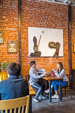 ENHANCING THE EXPERIENCE At Ascendo Coffee, work by artist Vincent Bernardy adds color and character to the cafe's exposed brick walls. - PHOTO BY JAYSON MELLOM