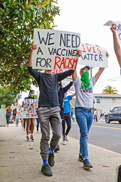 AGAINST POLICE VIOLENCE Protesters walk from Mitchell Park to downtown SLO as part of a Black Lives Matter rally on May 31. - PHOTO BY JAYSON MELLOM