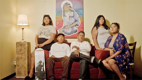 APACHE PROUD Nationally renowned artist Douglas Miles (center) sits with his family on the San Carlos reservation, from which he launched the popular skateboard company APACHE Skateboards. - PHOTOS COURTESY OF SLOMOTION