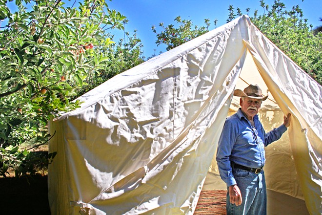 LEAVING A LEGACY Bill Spencer and his wife, Barbara, own Windrose Farms, east of Paso Robles. The couple will be honored with the Legacy Farmer of the Year award during the 32nd annual California Small Farm Conference, Feb. 27 to 29, at Cuesta College's North County campus. Here, Spencer checks out a canvas tent in preparation for the September 2014 Heirloom Tomato Festival.
