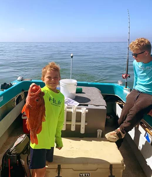 FISHY FISHY Eric Collier, 8, holds up the biggest catch of the day! A red rockfish that he caught himself out on the water near Port San Luis. - PHOTO COURTESY OF WIL COLLIER