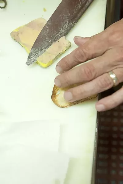 IN THE KITCHEN: : Laurent Grangien welcomed a Sun writer and photographer into his kitchen, where he sliced foie gras for sampling. - PHOTO BY STEVE E. MILLER