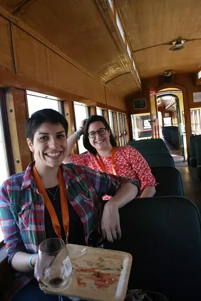 CHUG INTO CHOWTIME: Santa Margarita Ranch is known for its award-winning vineyards and ancient barn as well as the old timey train that chugs through the property during Sunset Savor the Central Coast each year. Pictured, New Times Arts Editor Jessica Peña and intern Adriana Catanzarite take a break from the food to travel back in time. - PHOTO BY HAYLEY THOMAS