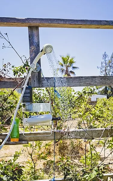 PASSIVE GRAY WATER : An outdoor shower in Cal Poly professor Pete Schwartz’s backyard supports thirsty berries, guava trees, and mint. No piping required. - PHOTO BY KAORI FUNAHASHI