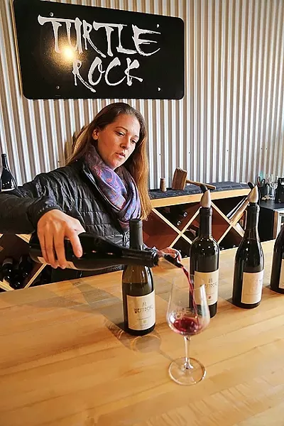 TURTLE ROCK: Claudia Burns of Turtle Rock Wines pours a splash of small-batch Zinfandel at Paso Underground, an eclectic wine hub hidden in downtown Paso Robles. The family-owned winery creates artisanal wines from fruit sourced from the Willow Creek District. - PHOTO BY DYLAN HONEA-BAUMANN