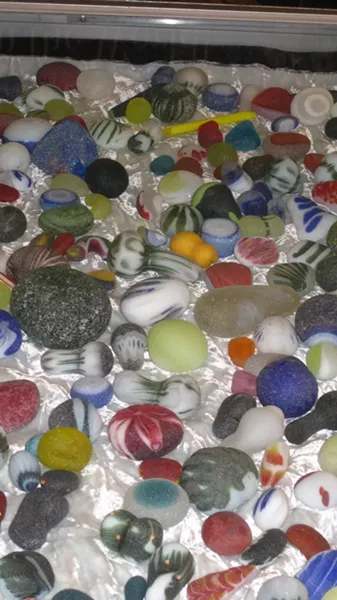 OLD ART, NEAT GLASS: Some of James Lundgren’s finished work sits in the Smithsonian; these botched throwaways were tossed by waves for decades to become the cool collection pictured here.